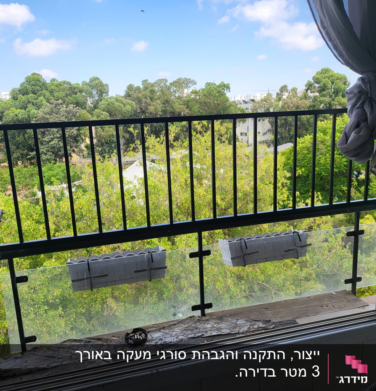 מעקה ברזל עם אדניות תלויות על מסגרת זכוכית